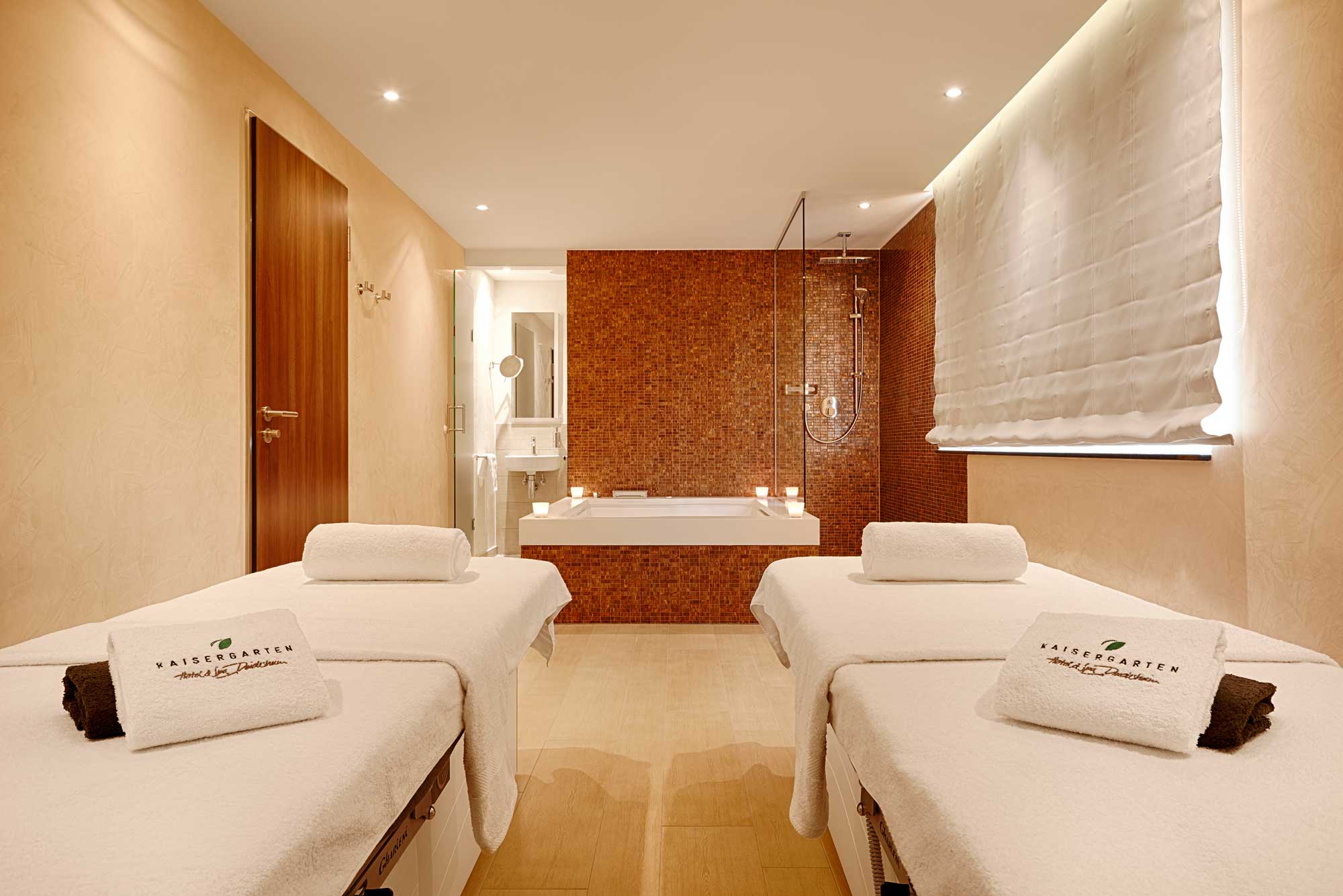 Räumlichkeit für Massage-Anwendungen in unserem Wellnesshotel Kaisergarten Deidesheim/Pfalz. Zwei Massageliegen für Paaranwendungen, Whirlwanne für zwei Personen, Dusche, Waschbecken, Toilette.