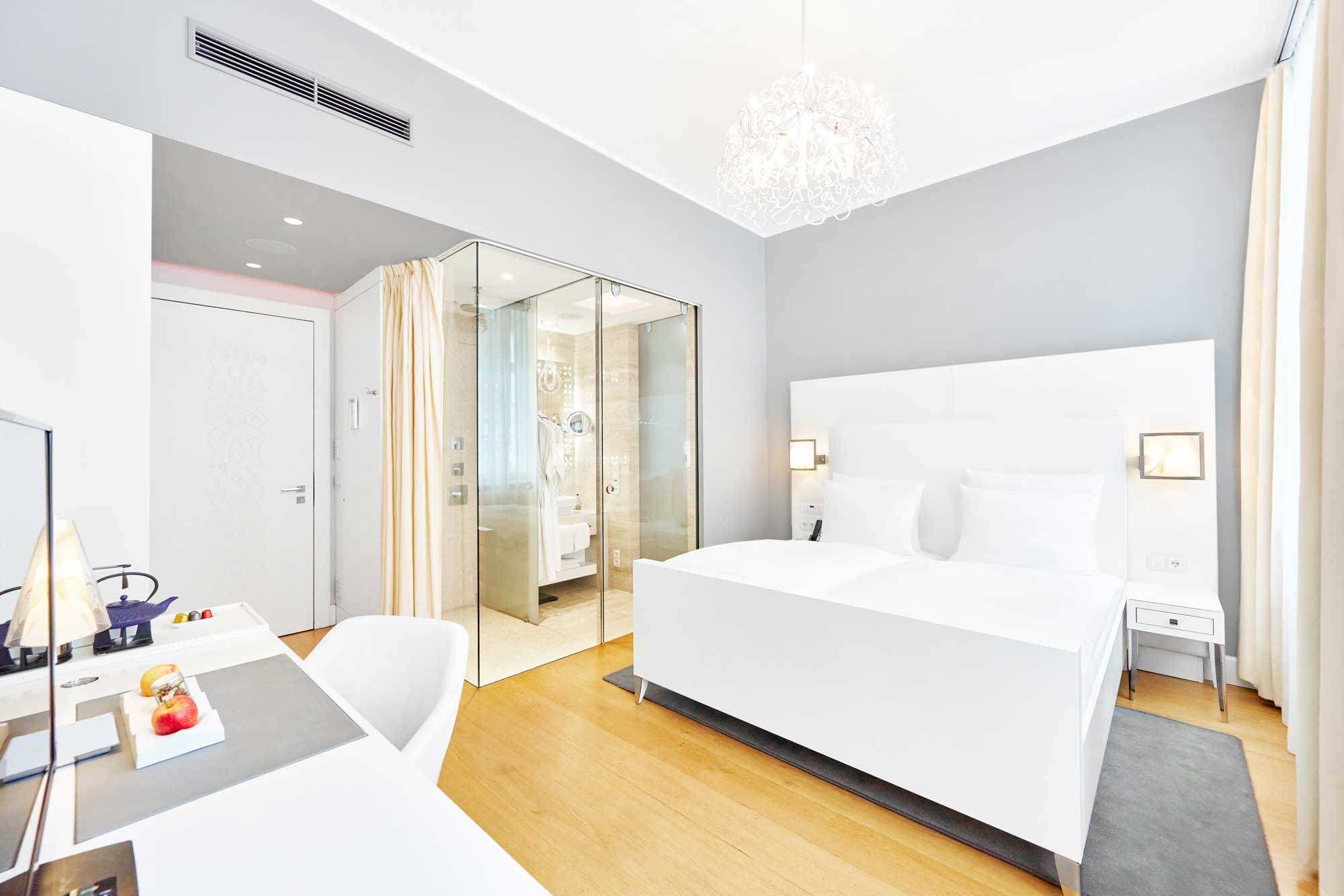 Standardzimmer im Genusshotel Ketschauer Hof in Deidesheim/ Pfalz. Luxuriöser Charme in wohliger Rückzugs-Atmosphäre für einen exklusiven Aufenthalt für zwei. Das Wohlfühl-Interior überzeugt mit klaren Weiß- und Grautönen, einer hochwertigen Zimmerausstattung, Design-Möbel, Eichenholzboden und teilweise getrennte Dusch- und Badeeinheiten, teilweise mit Whirlwanne.