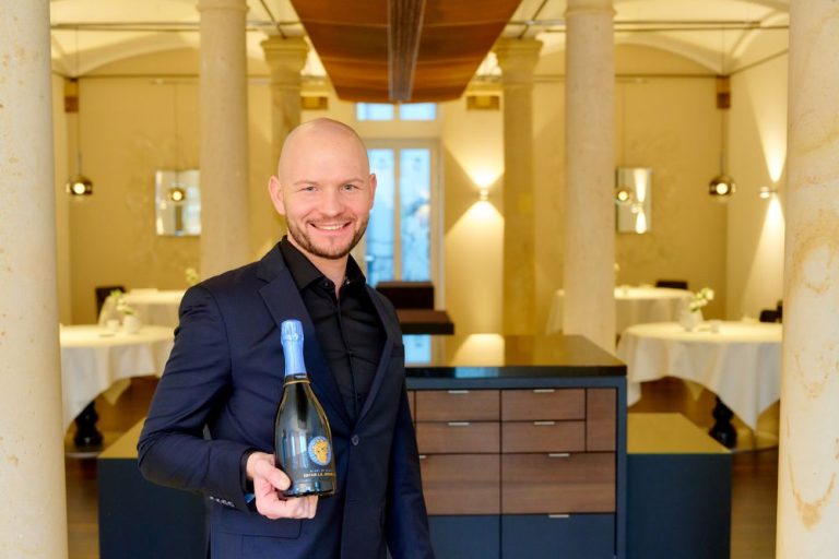 Stephan Nitzsche, Sommelier des 2-Sterne-Gourmetrestaurants L. A. Jordan. Hier stehend im Restaurant, in der Hand eine Flasche "Prestige" vom Schwesterweingut Reichsrat von Buhl.